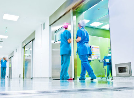 Due infermieri in corridoio ospedaliero.